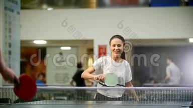 打乒乓球。 年轻的微笑女子喜欢打乒乓球